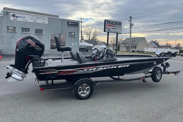 The Image of 2023 Tracker Pro Team 190 TX boat on trailer, parked outdoors near dealership. - 0