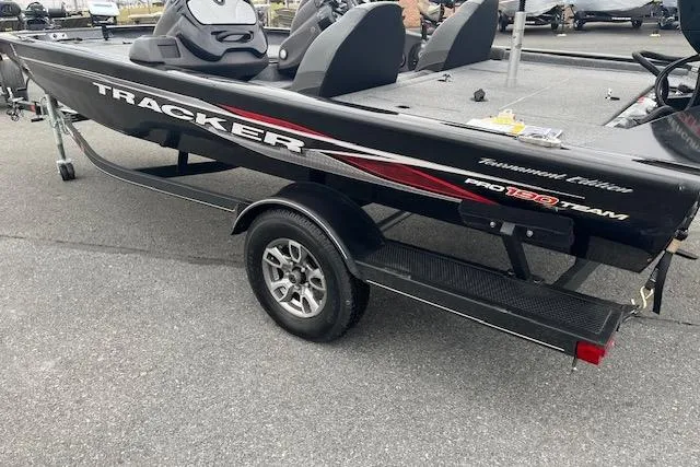 Slide: The Image of 2023 Tracker Pro Team 190 TX boat on trailer, black with red accents. - 2