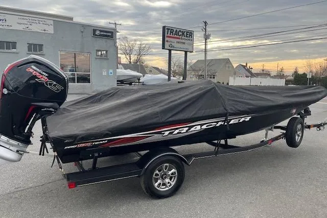 Slide: The Image of 2023 Tracker Pro Team 190 TX boat with cover on trailer, parked outdoors. - 9