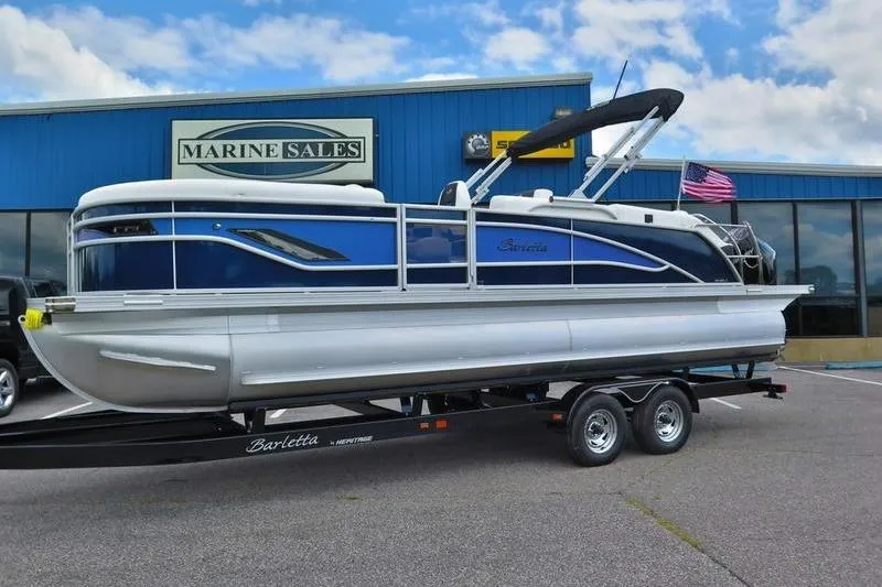 The Image of 2025 Barletta Corsa 23UC pontoon boat on trailer at marine sales dealership. - 1