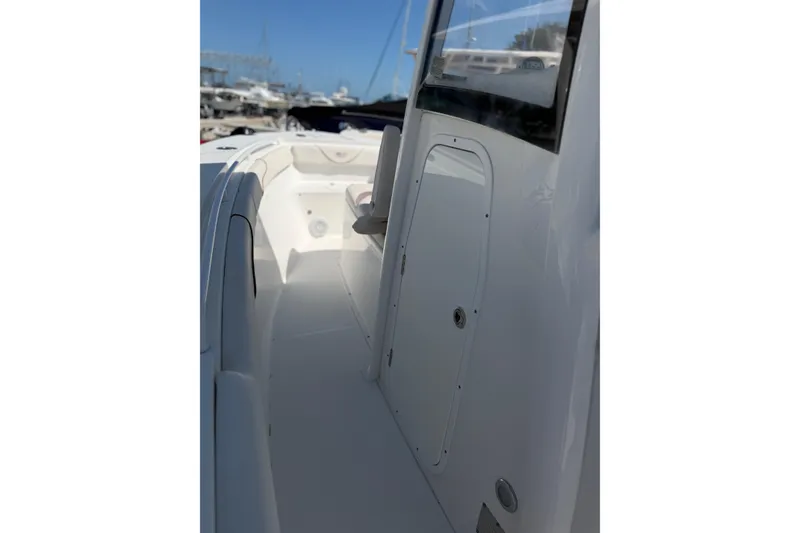Slide: The Image of 2019 Sea Hunt Gamefish 27 boat interior with sleek white design and storage compartment. - 10