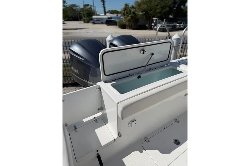 Slide: The Image of 2019 Sea Hunt Gamefish 27 boat with open storage compartment and dual Yamaha engines. - 15