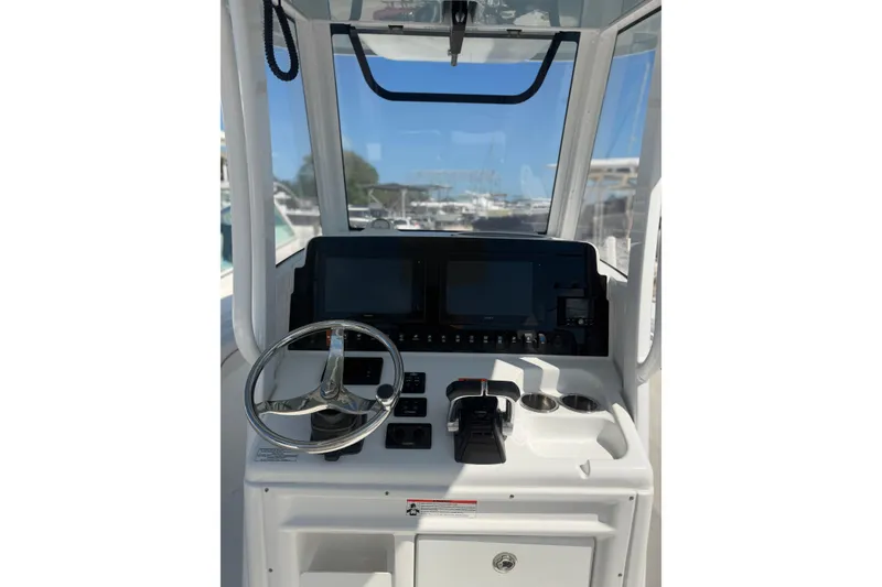 Slide: The Image of 2019 Sea Hunt Gamefish 27 helm with steering wheel and navigation controls. - 5