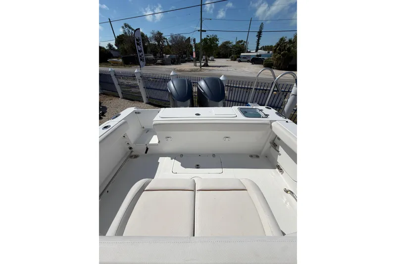 Slide: The Image of 2019 Sea Hunt Gamefish 27 boat interior with dual engines, white seating, and clear sky. - 6