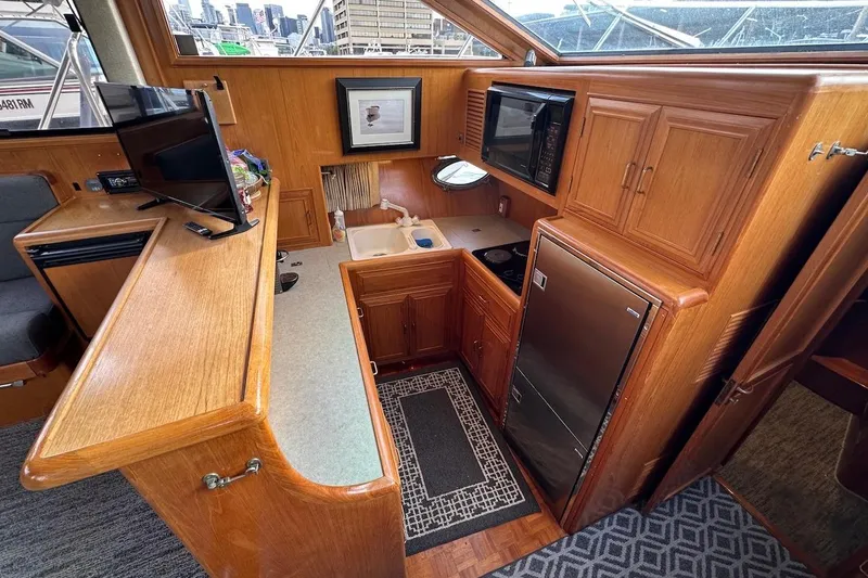 Slide: The Image of Luxurious 1993 Ocean Alexander 460 yacht interior with kitchen, TV, and wooden cabinetry. - 44