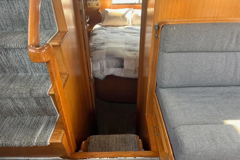 Slide: The Image of Interior of 1993 Ocean Alexander 460 yacht, featuring cozy bedroom and wooden staircase. - 51