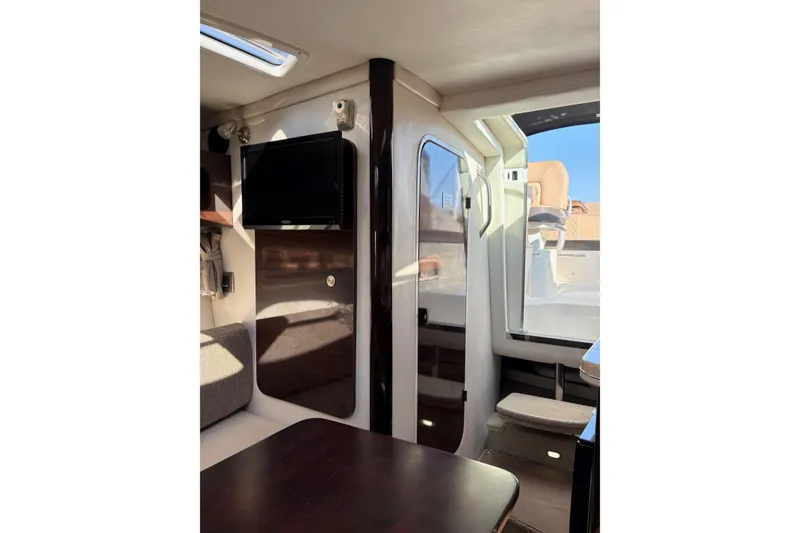 Slide: The Image of Interior of 2016 Sea Ray Sundancer 260 with TV, seating, and cabin door. - 5