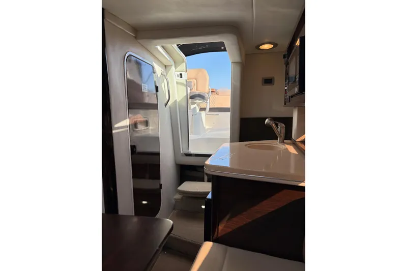 Slide: The Image of Interior view of 2016 Sea Ray Sundancer 260 boat, featuring a compact kitchenette. - 6