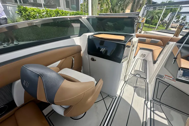 Slide: The Image of 2019 Four Winns HD270 OB boat interior with tan and black seating, sleek design. - 10