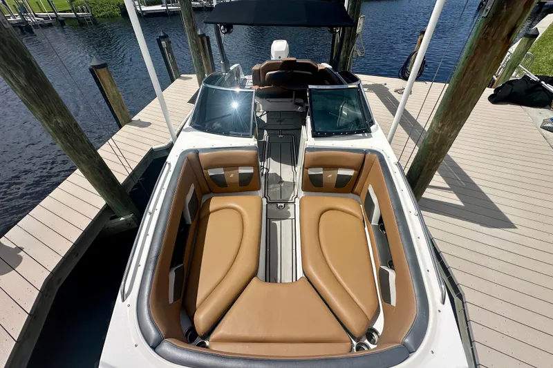 Slide: The Image of 2019 Four Winns HD270 OB boat with tan seating docked by the water. - 13