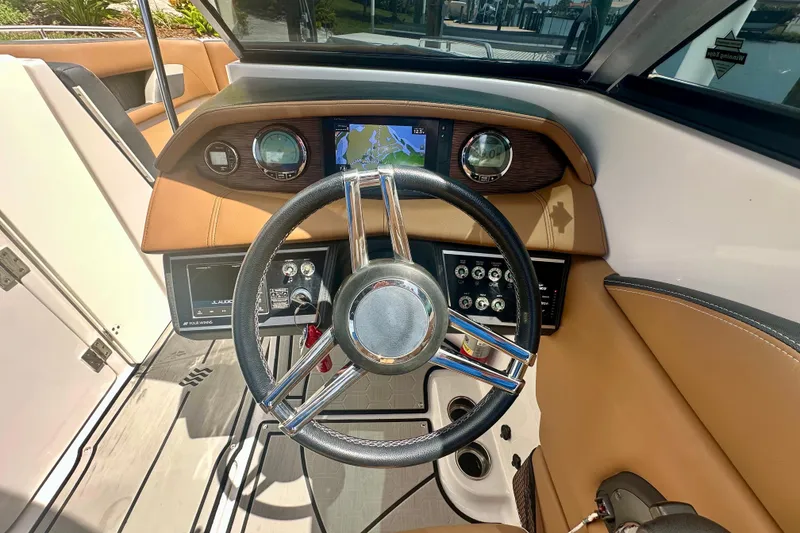 Slide: The Image of 2019 Four Winns HD270 OB boat dashboard with steering wheel and navigation display. - 15