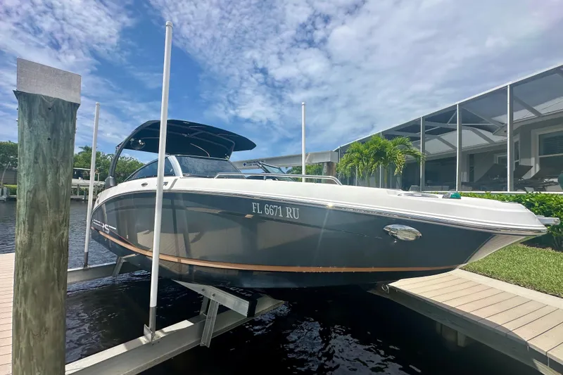 Slide: The Image of 2019 Four Winns HD270 OB boat docked under a clear blue sky. - 24