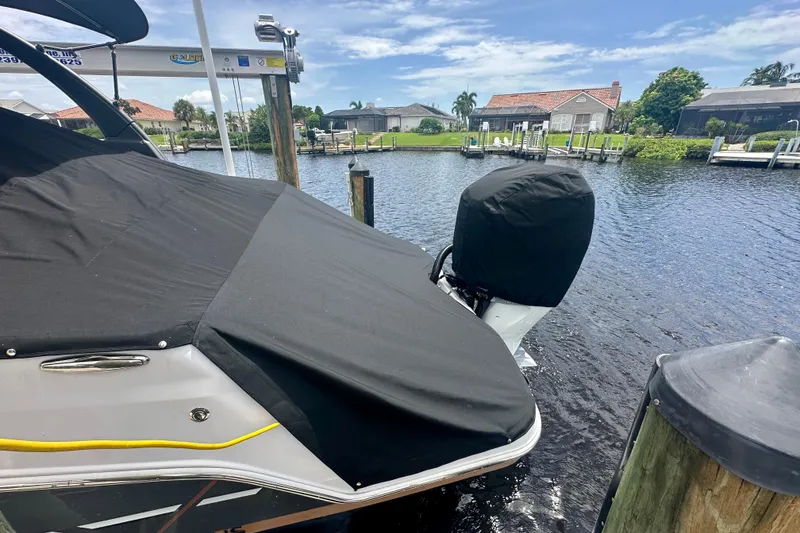 Slide: The Image of 2019 Four Winns HD270 OB boat docked, covered, with scenic waterfront view. - 25