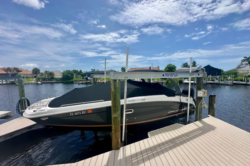Slide: The Image of 2019 Four Winns HD270 OB boat docked under a clear blue sky. - 26