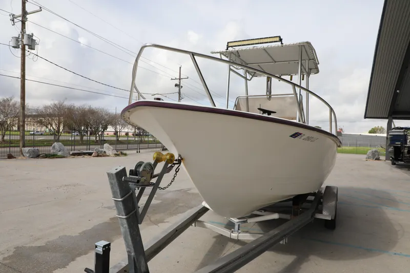 Slide: The Image of 2002 Cape Craft 210 Center Console boat on trailer, parked outdoors. - 2