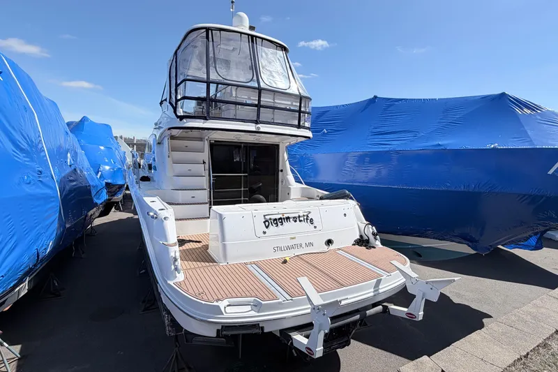 Slide: The Image of 2006 Sea Ray 52 Sedan Bridge yacht docked, rear view, with blue tarps in background. - 1