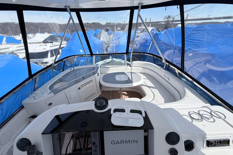 Slide: The Image of 2006 Sea Ray 52 Sedan Bridge cockpit with Garmin navigation, surrounded by blue-covered boats. - 13