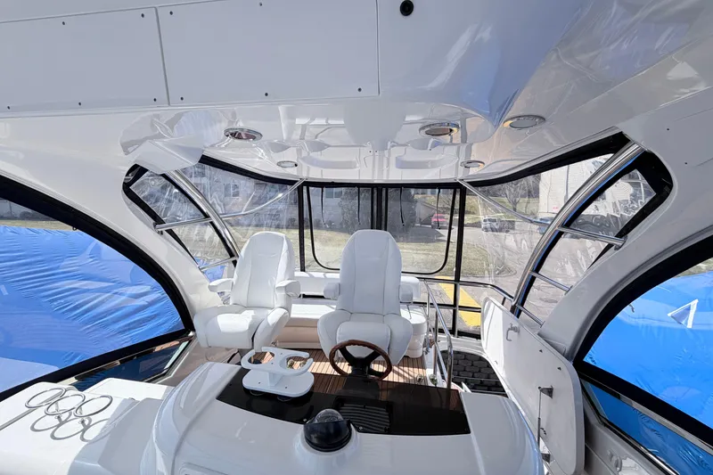 Slide: The Image of Interior view of a 2006 Sea Ray 52 Sedan Bridge yacht cockpit with white seating. - 17
