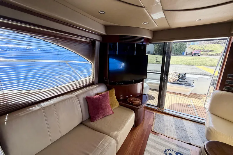 Slide: The Image of Luxurious interior of 2006 Sea Ray 52 Sedan Bridge yacht with plush seating and TV. - 23