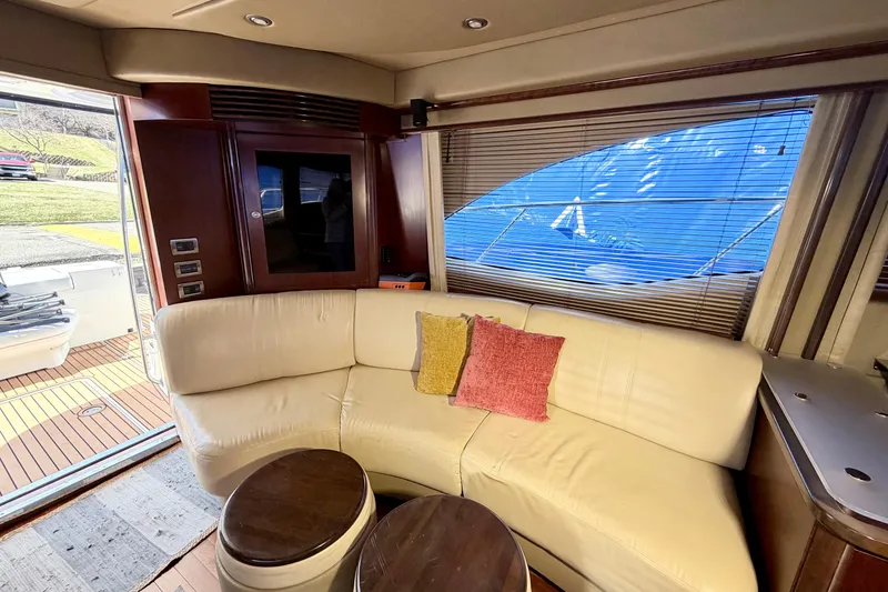 Slide: The Image of Interior of 2006 Sea Ray 52 Sedan Bridge yacht with cream sofa and colorful cushions. - 24