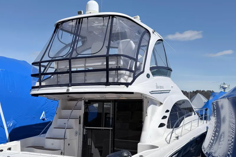 Slide: The Image of 2006 Sea Ray 52 Sedan Bridge yacht with enclosed flybridge, docked under clear skies. - 3