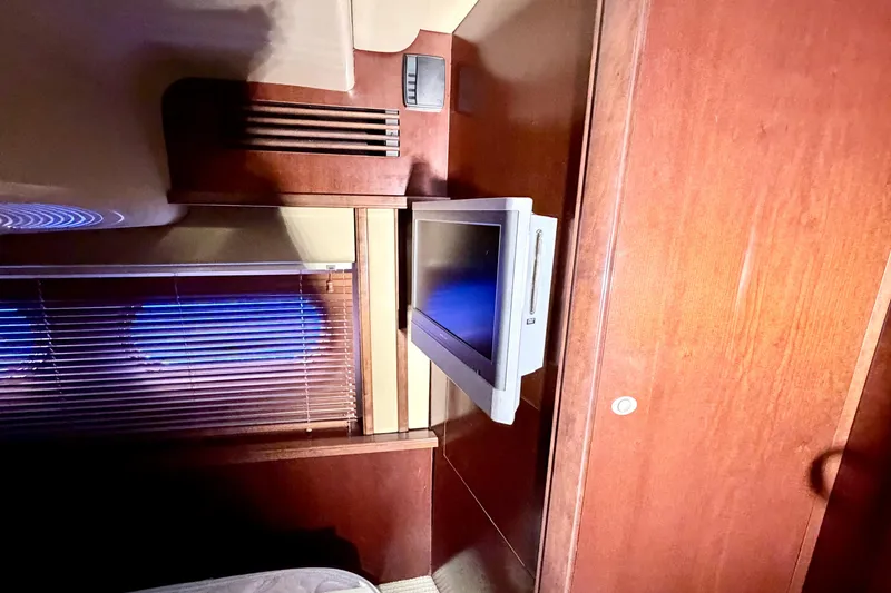 Slide: The Image of Interior of 2006 Sea Ray 52 Sedan Bridge with mounted TV and wooden paneling. - 38