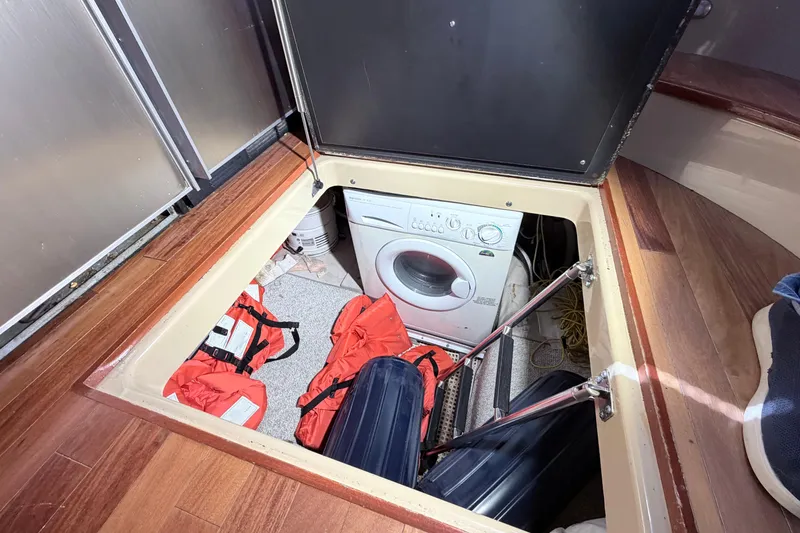 Slide: The Image of Hidden laundry area with washer and life jackets on 2006 Sea Ray 52 Sedan Bridge. - 42