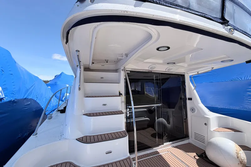Slide: The Image of 2006 Sea Ray 52 Sedan Bridge yacht with stairs and deck, under blue sky. - 5