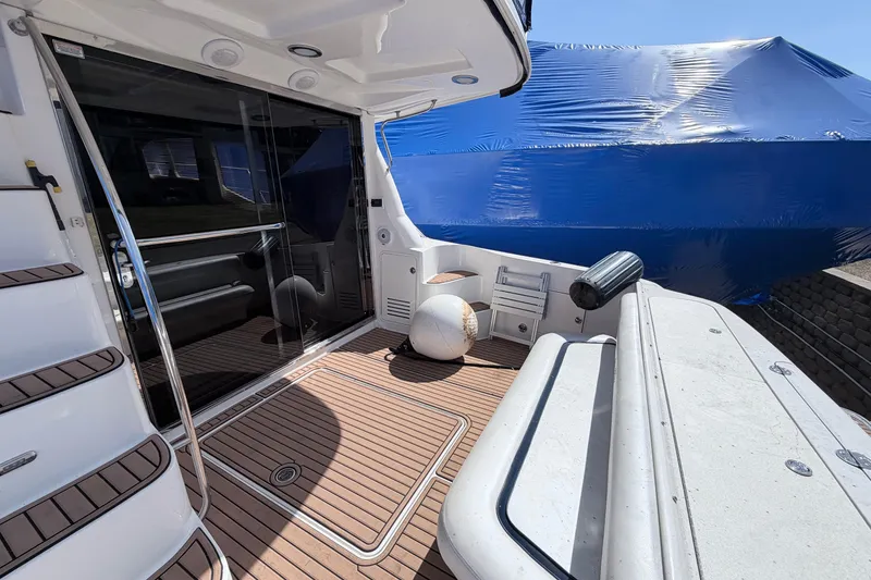 Slide: The Image of 2006 Sea Ray 52 Sedan Bridge yacht deck with wooden flooring and seating area. - 6