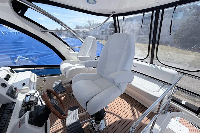 Slide: The Image of Interior of 2006 Sea Ray 52 Sedan Bridge yacht with white captain's chairs and wooden accents. - 9