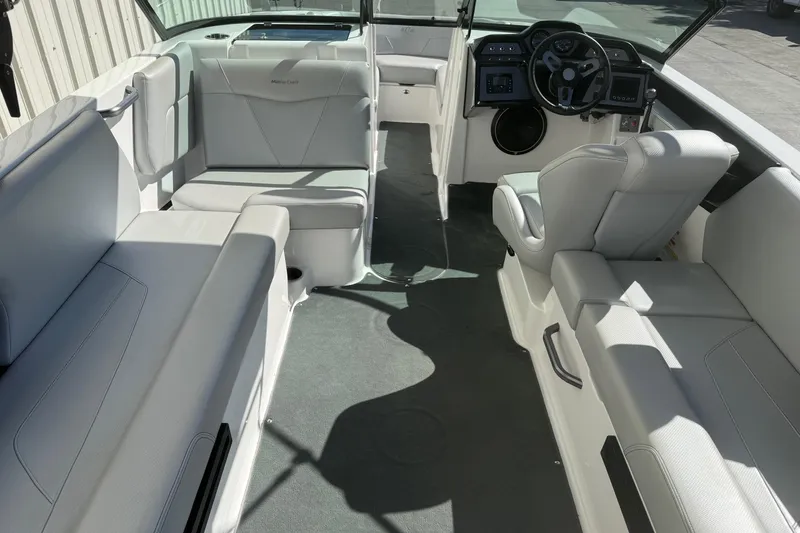 Slide: The Image of 2020 MasterCraft NXT22 boat interior with white seating and modern dashboard. - 11