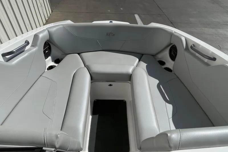 Slide: The Image of 2020 MasterCraft NXT22 boat interior with gray seating and cup holders. - 12
