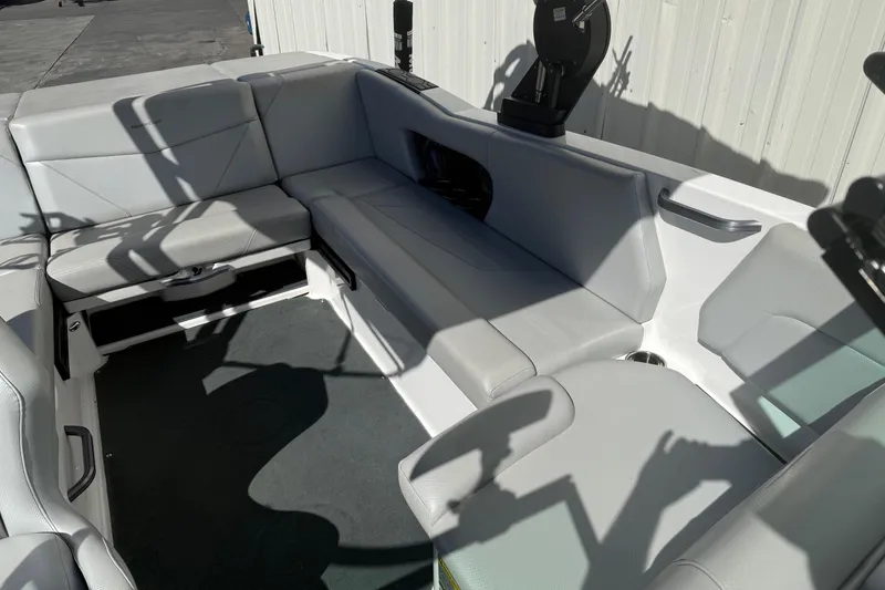 Slide: The Image of 2020 MasterCraft NXT22 boat interior with gray seating and storage compartments. - 14