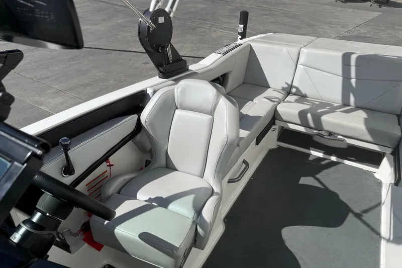 Slide: The Image of 2020 MasterCraft NXT22 boat interior with gray seating and steering console. - 15