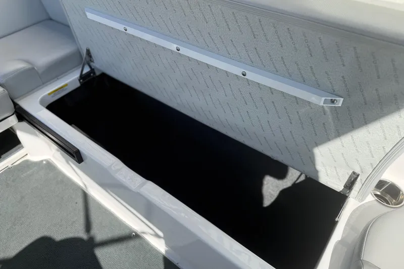 Slide: The Image of 2020 MasterCraft NXT22 boat storage compartment with open lid, showcasing interior space. - 20