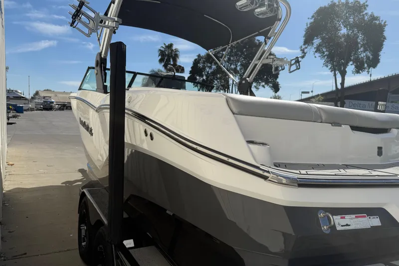 Slide: The Image of 2020 MasterCraft NXT22 boat on trailer, parked outdoors under a clear blue sky. - 4