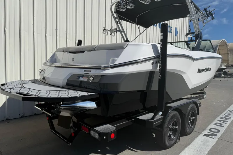 Slide: The Image of 2020 MasterCraft NXT22 boat on trailer, parked outdoors near a building. - 8