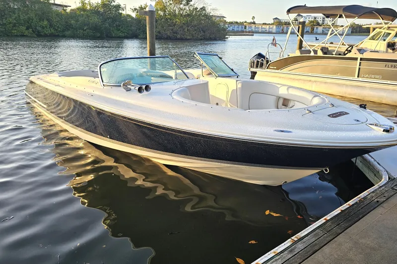 The Image of 2003 Chris-Craft Launch 28 boat docked on calm water, showcasing sleek design. - 0