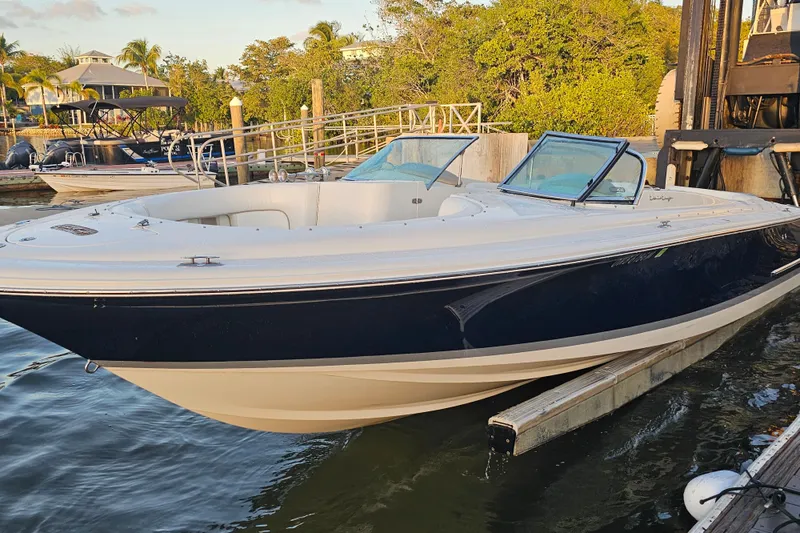 Slide: The Image of 2003 Chris-Craft Launch 28 boat docked at a marina, surrounded by lush greenery. - 3