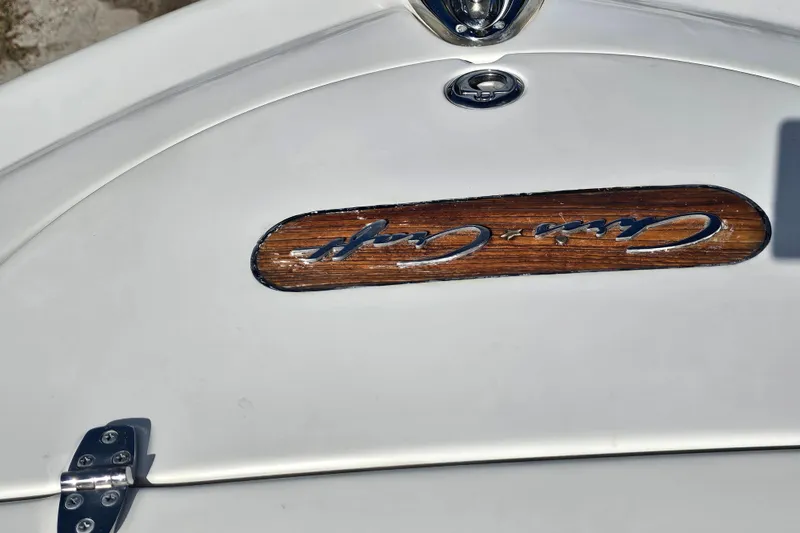 Slide: The Image of 2003 Chris-Craft Launch 28 boat emblem on white surface with wood accent. - 7