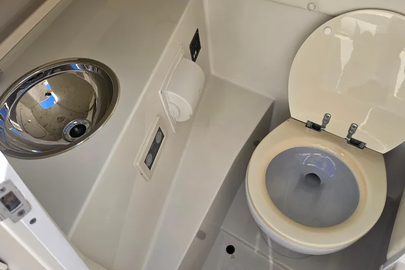 Slide: The Image of 2003 Chris-Craft Launch 28 boat bathroom with toilet and stainless steel sink. - 8