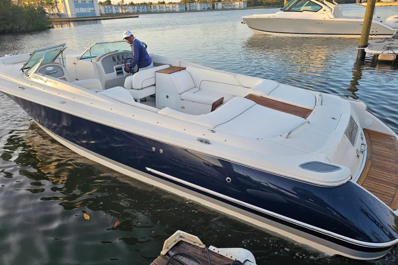 Slide: The Image of 2003 Chris-Craft Launch 28 boat emblem on white surface with wood accent. - 13