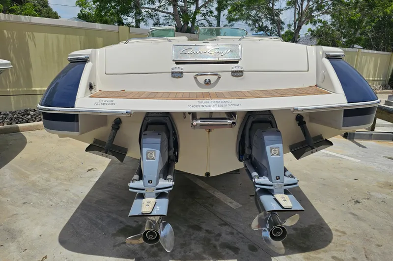 Slide: The Image of 2008 Chris-Craft Launch 28 boat, rear view with dual outboard motors, parked on concrete. - 4