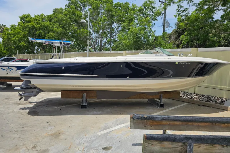Slide: The Image of 2003 Chris-Craft Launch 28 boat docked on calm water, showcasing sleek design. - 7