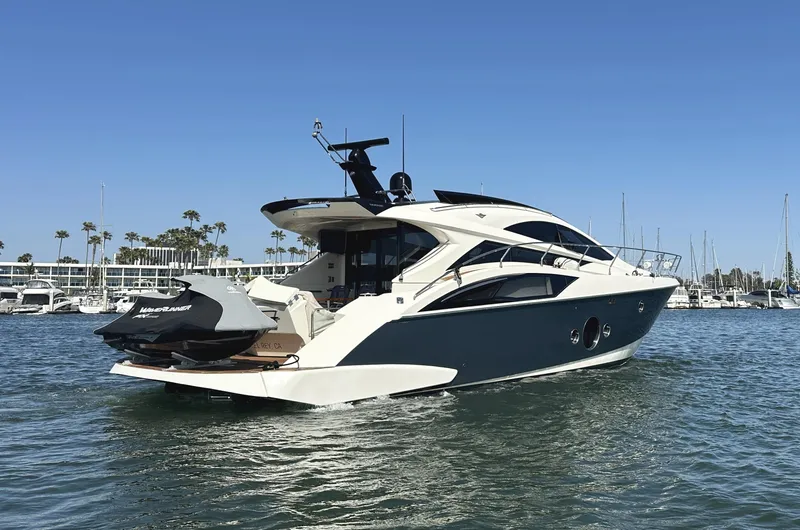 Slide: The Image of 2011 Marquis Sport Coupe yacht on water, clear sky, marina background. - 6