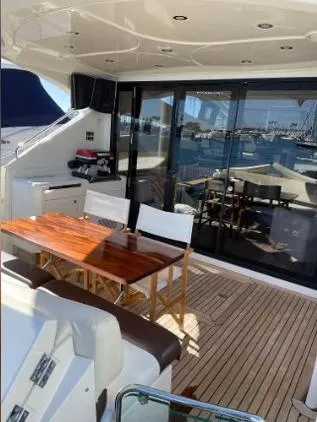 Slide: The Image of 2011 Marquis Sport Coupe yacht with elegant deck seating and wooden table. - 8