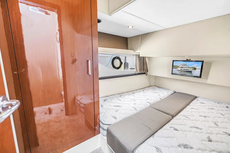 Slide: The Image of Luxurious cabin interior of 2018 Carver 40 Command Bridge yacht with twin beds and TV. - 34