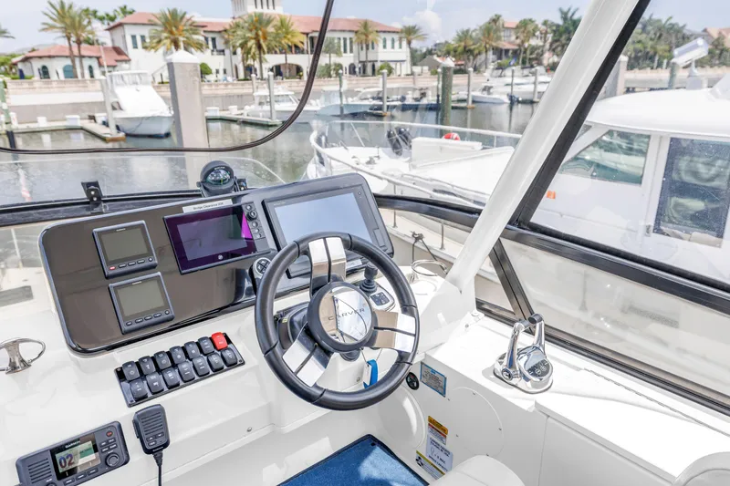 Slide: The Image of 2018 Carver 40 Command Bridge helm with modern navigation equipment at a marina. - 36