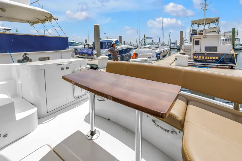 Slide: The Image of Luxurious 2018 Carver 40 Command Bridge yacht interior with elegant seating and wooden table at marina. - 40