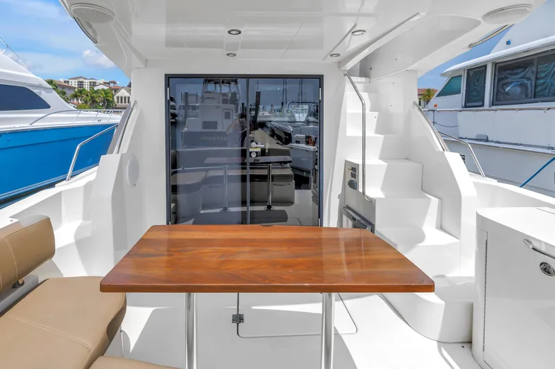 Slide: The Image of 2018 Carver 40 Command Bridge yacht interior with wooden table and seating area. - 41